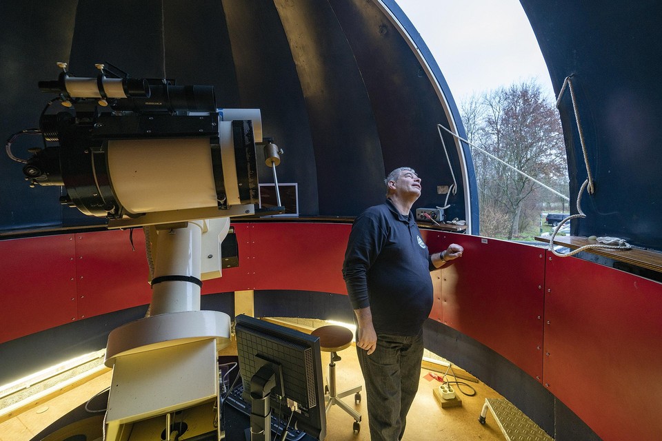 Voorzitter Paul Volman kijkt door de geopende koepel bij de sterrenwacht naar buiten.