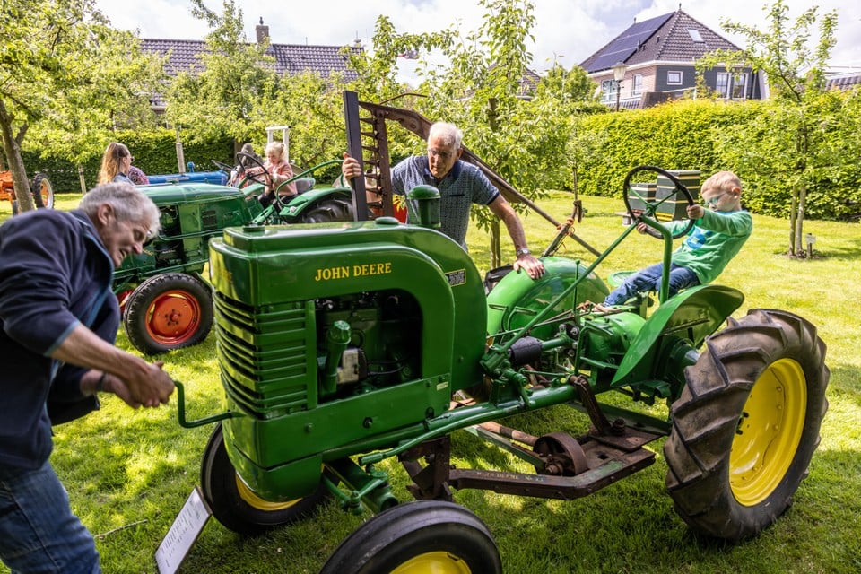 Op het grasveld van Agrarisch Museum Westerhem staan oude tractoren ter bezichtiging opgesteld. De opa van Stijn (rechts achter het stuur) slingert te vergeefs de motor aan.