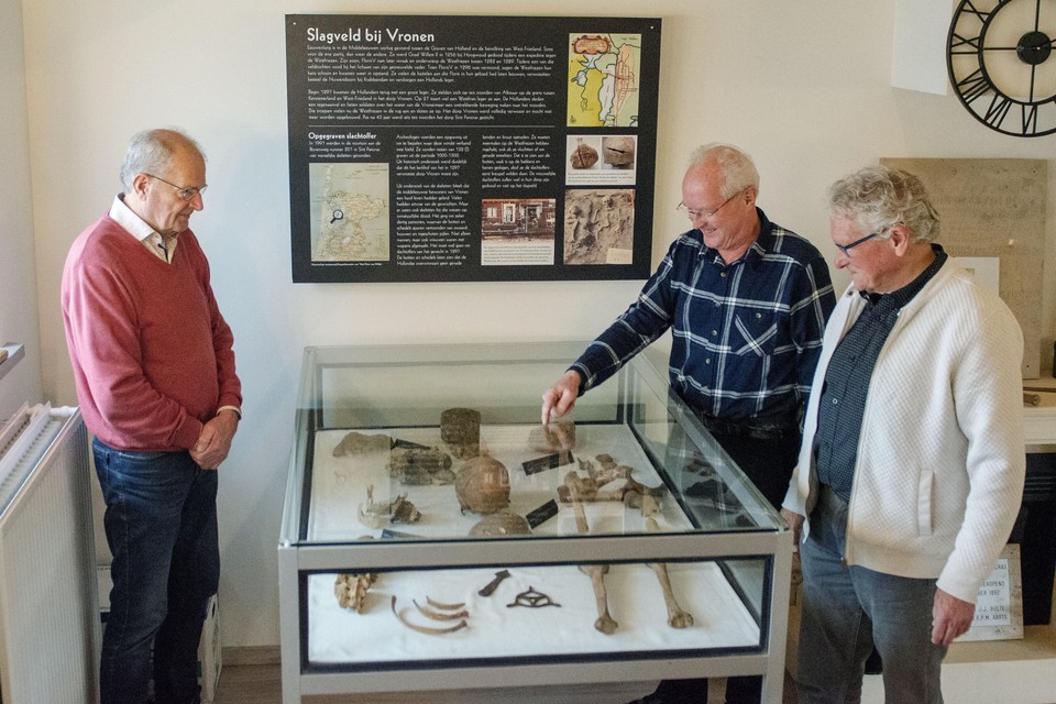 Drie leden van de Historische Vereniging Sint Pancras bij de vitrine met vondsten van de slag bij Vronen. V.l.n.r. Bram Kout, Harry Olie en Jan Steltenpool.
