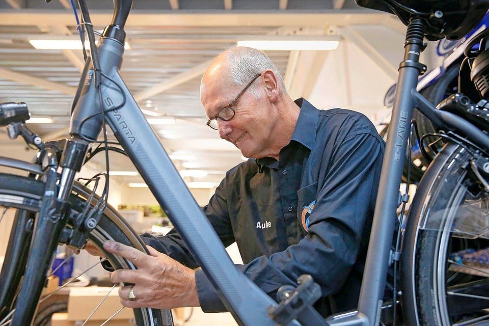 Auke Hofstra aan het werk. Hij stopt na veertig jaar als rijwielhersteller.