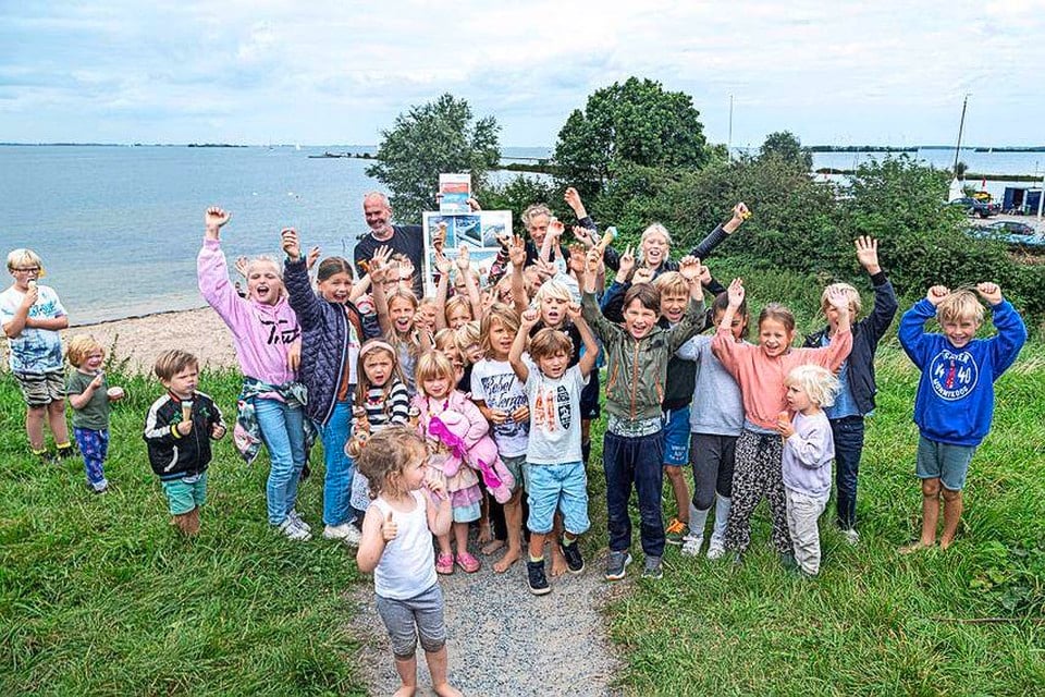Kinderen uit de wijk De Krijgsman zijn blij met het rapport van Arcadis over de uitbreiding van het strandje achter hen.
