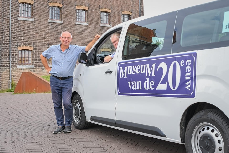 Hans Stuijfbergen bij de elektrische taxibus van het Museum van de Twintigste Eeuw, met Dick van der Pijl achter het stuur.