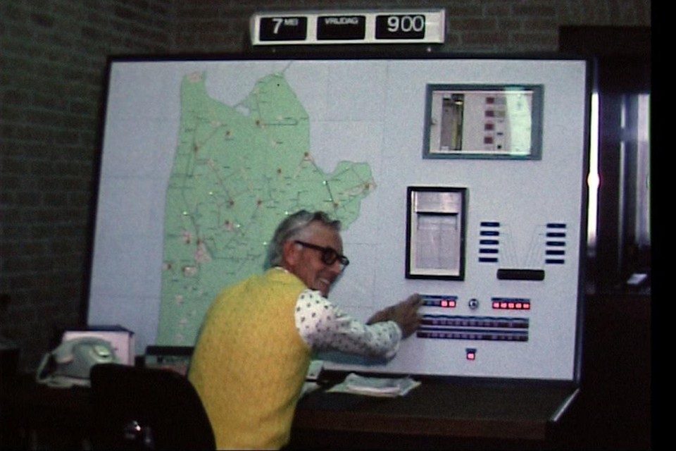 Een groot paneel met een overzichtskaart van het werkgebied wordt bediend door een vriendelijk lachende medewerker van het gasbedrijf. Er boven een grote klok die nu ‘retro’ genoemd wordt. Het is vrijdag 7 mei en negen uur in de ochtend; het begin van de Open Dag 1976.