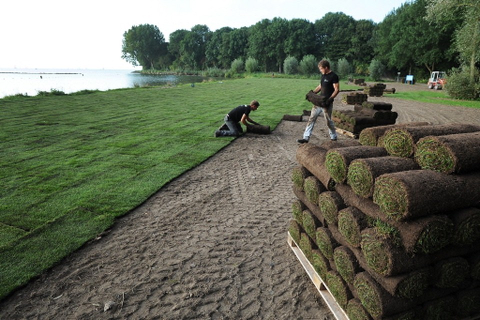 Graszoden worden gelegd op het terrein in het Julianapark in Hoorn. foto theo groot