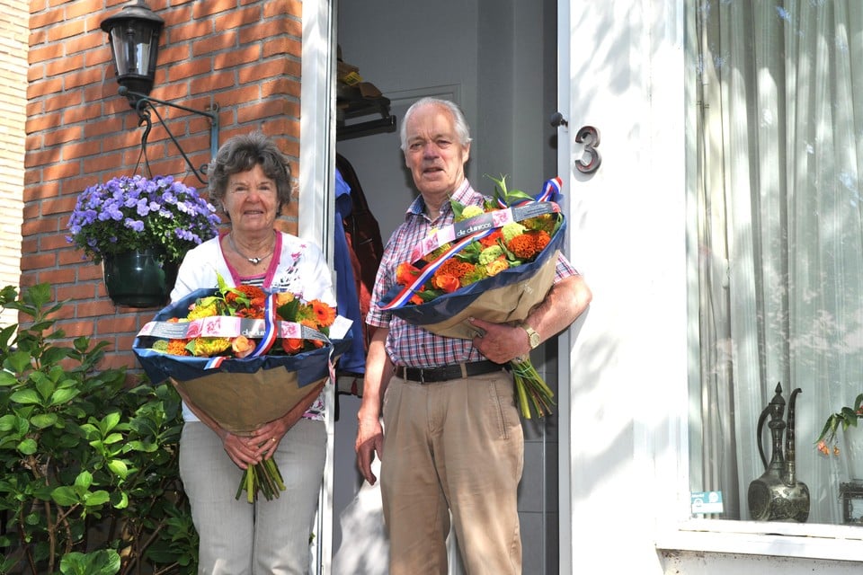 Het echtpaar Bets en Simon van Rookhuizen, allebei met een boeket bloemen van De Duinroos die ze van de gemeente Beverwijk hebben gekregen.