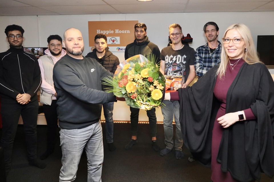 Appie Azzouzi, en met hem de jongeren van de Waal Handjes achter hem, wordt door wethouder Kholoud Al Mobayed in de bloemetjes gezet.