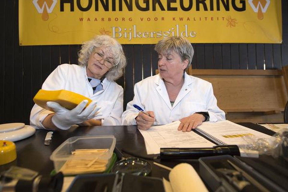 Jeltje Poort en Jeanine Slot keuren een stuk bijenwas.