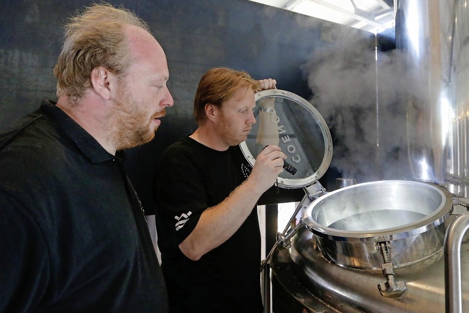 Bedrijfsleider Pieter Boy (l) en brouwbegeleider Eric van der Lugt inspecteren de inhoud van een van de ketels van brouwerij De Werf.