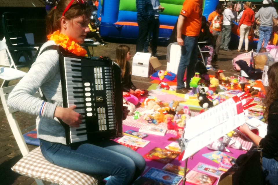 Madelief Doeleman (16) uit Valkkoog speelt op de harmonica tijdens de vrijmarkt in Schagen.