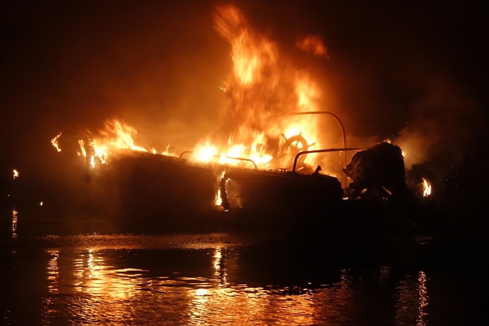 De vlammen laaien hoog op het bootje bliksesnel tot de waterlijn afbrandt.