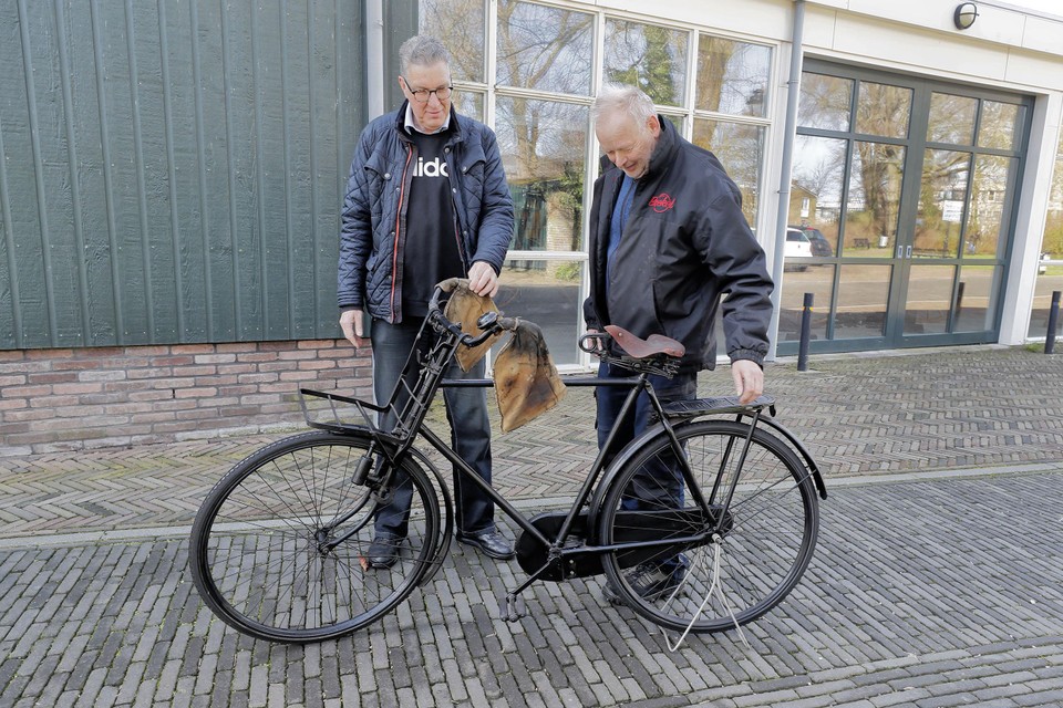 Niekjan Grooff (l) neemt de fiets in ontvangst. Naast hem Ben Boekel die de fiets namens Aad Kramer kwam brengen.