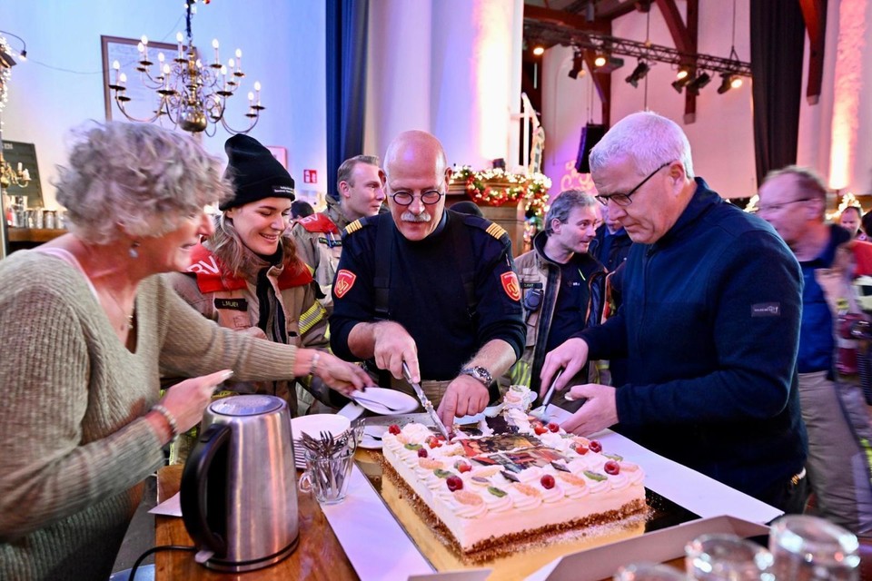 Herman (derde van links) snijdt met zijn vrouw en dochter de taart aan.