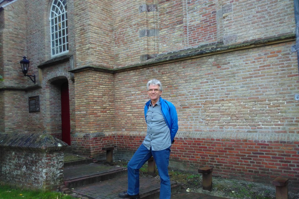 Ds. André Wingelaar voor de kerk in Warmenhuizen.