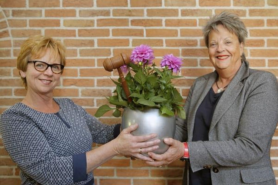 Jacqueline Brander-Keezer (links) krijgt van Gea Breebaart de voorzittershamer overhandigd; in een passende verpakking.