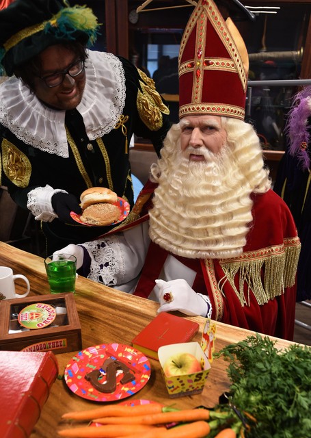 Sinterklaas krijgt een broodje aangereikt bij zijn ontbijt in Hoorn.