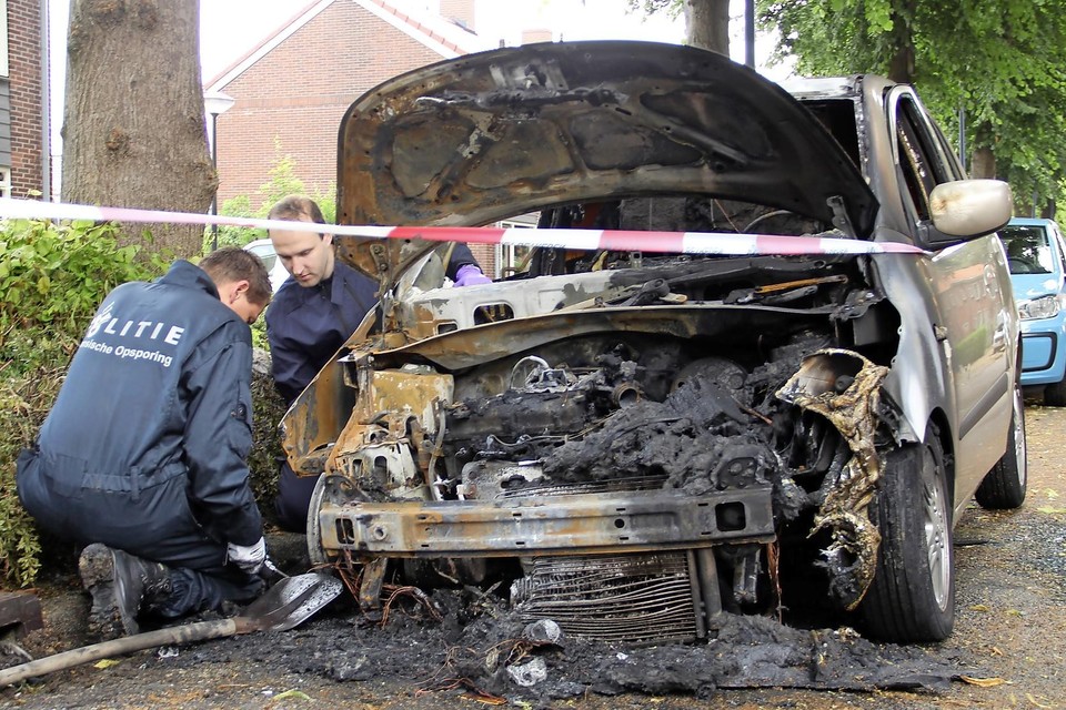 Politie doet sporenonderzoek bij uitgebrande auto van het getroffen gezin.