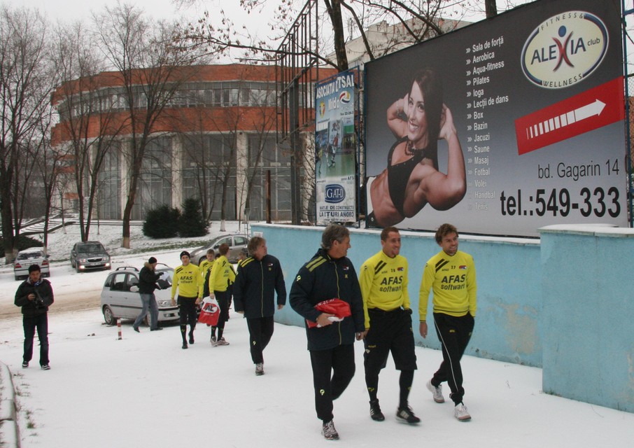 Spelers van AZ (en trainer Gertjan Verbeek, in het midden) in de sneeuw op weg naar een gymzaal in Chisinau. Daar werkte AZ op de ochtend voor de wedstrijd nog een lichte training af.
