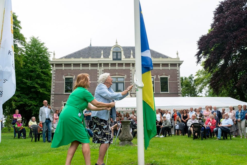 Marleen Jaspers en Mayke Posch hijsen samen de vlag van de Schermer bij de opening van Wittenburg als zorghuis.