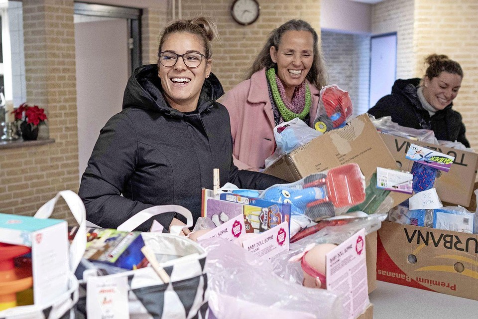 Dochters Sanne (voor) en Maartje (achter) assisteren Annemieke bij het uitladen van de cadeaus.