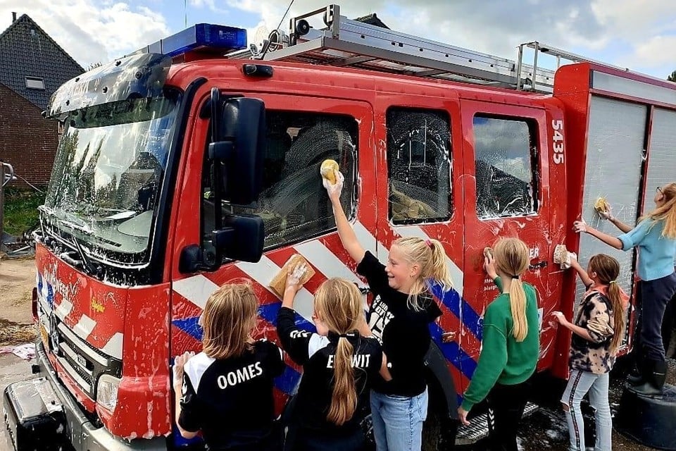 De DWB-meiden halen de brandweerwagen door een sopje.