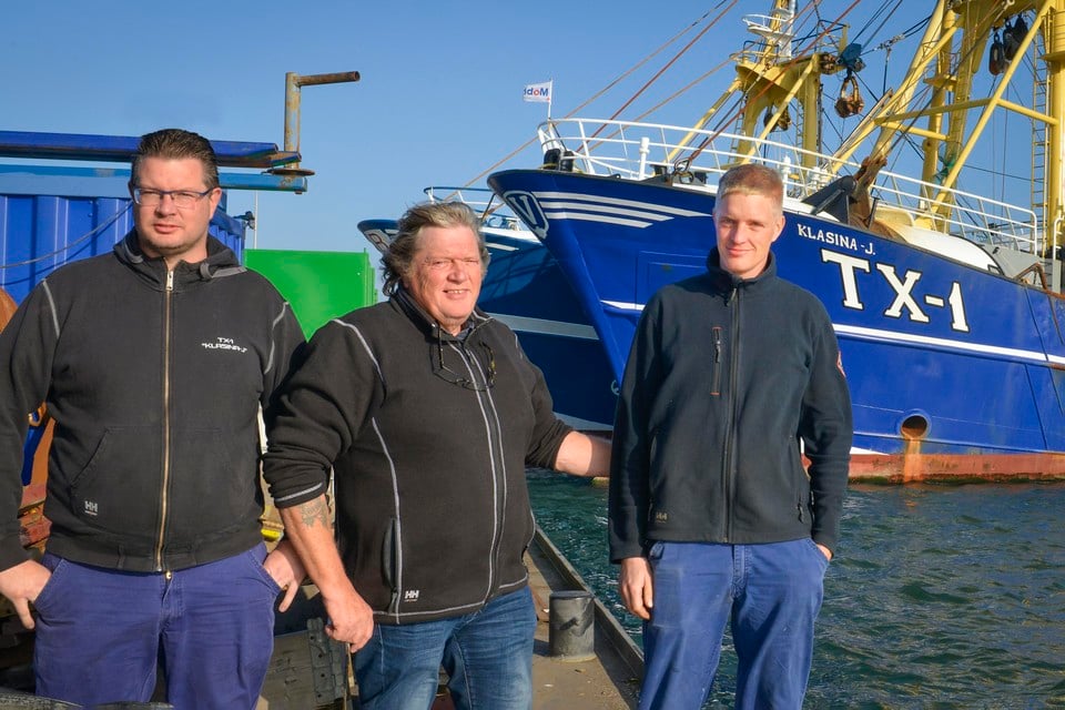 Cor, Adrie en Thijs Vonk voor hun schip, de TX1 Klasina-J., in de haven van Oudeschild.