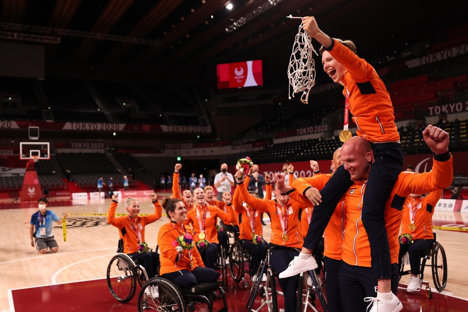 Speelster Bo Kramer ging na de gouden finale in Tokio bij Jan de Wit op de schouders om het netje van de basket af te knippen.