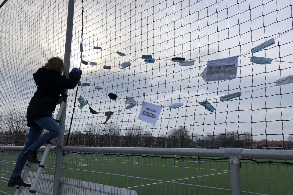 De slingers worden door vrijwilliger Inge Vlaar opgehangen bij een sportvereniging in West-Friesland