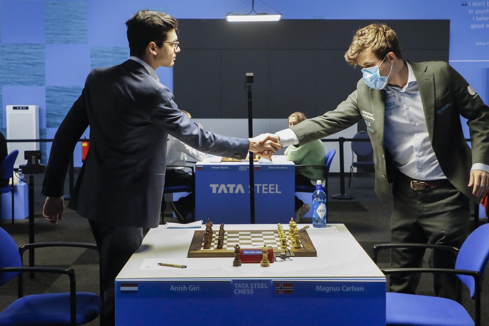 De schakers van Tata Steel Chess gaan verschillend met de coronamaatregelen om. Anish Giri en Magnus Carlsen gaven elkaar ’gewoon’ een hand.