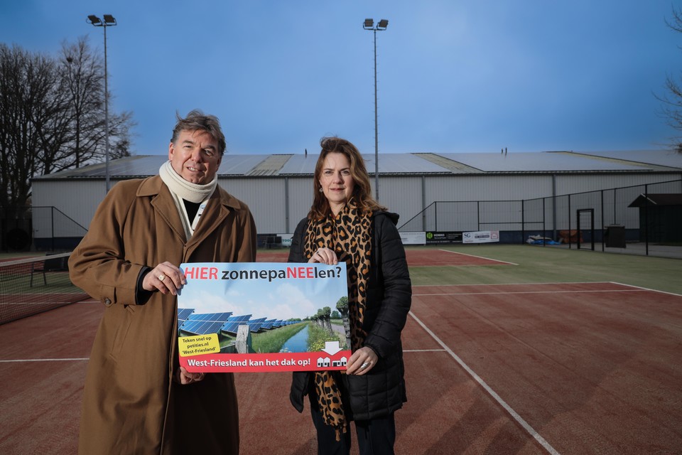 Irma Stroet en Erik Mooij op het tennispark met op de de achtergrond sportcentrum De Weyver in Hoogwoud. Hier liggen 725 zonnepanelen op daken, de helft van de beschikbare oppervlakte.