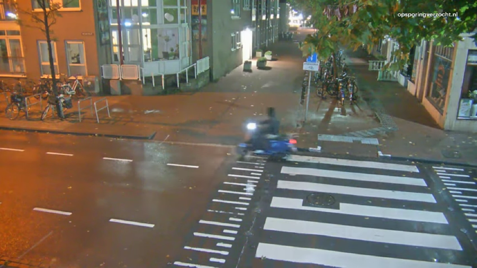 De dader rijdt vlak voor de brand rustig op een scooter door de straat.