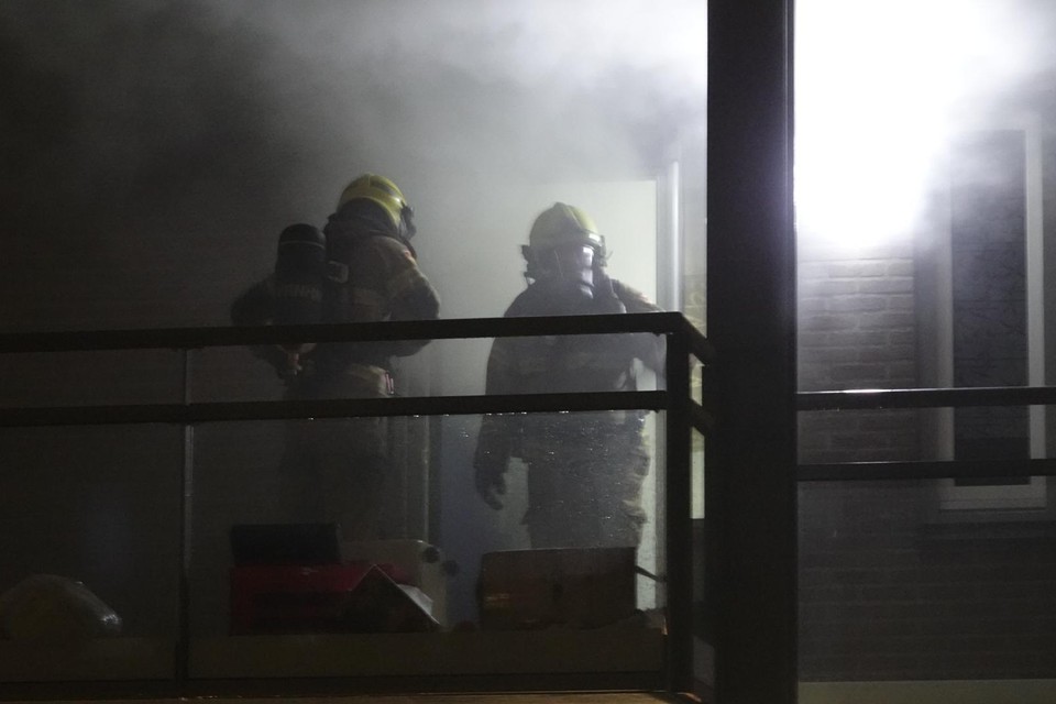 De brandweer controleert het rokende appartement in Enkhuizen.
