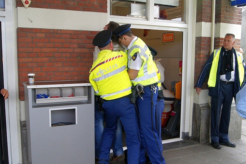 Een schreeuwende man wordt in de boeien geslagen op het station van Hoorn.