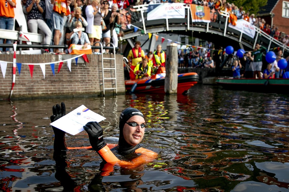 Olympisch zwemkampioen Maarten van der Weijden bij het 'stempelpunt' in Sneek op de eerste dag van zijn Elfstedenzwemtocht.