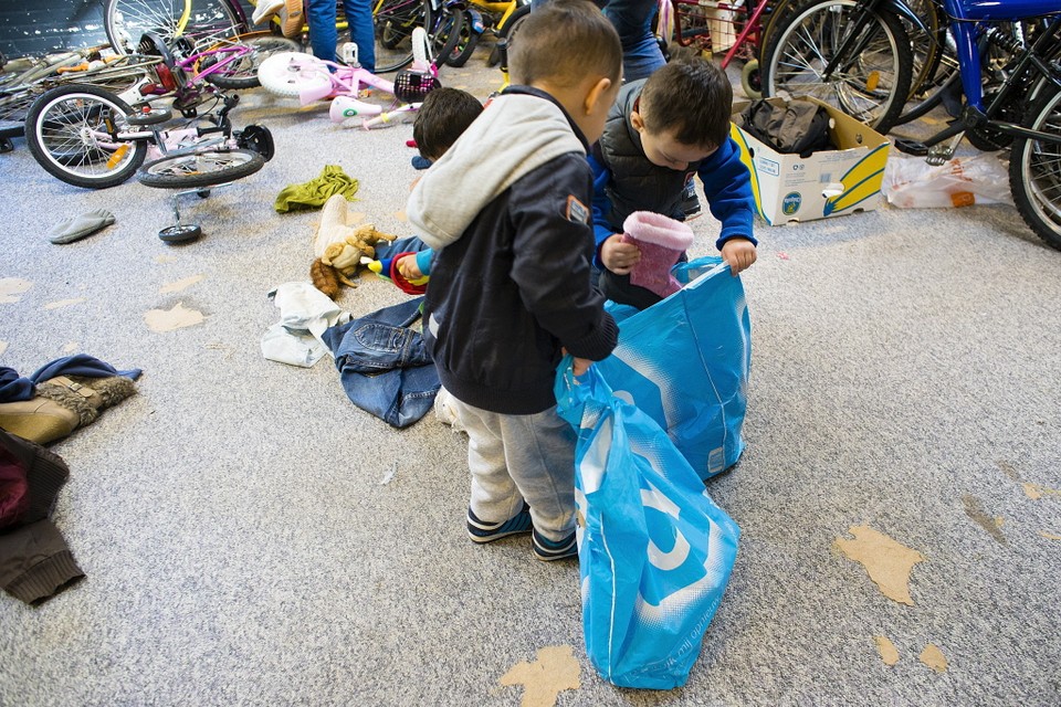 Kinderen zoeken schoenen uit tussen de gedoneerde spullen. Foto JJfoto/Jan Jong