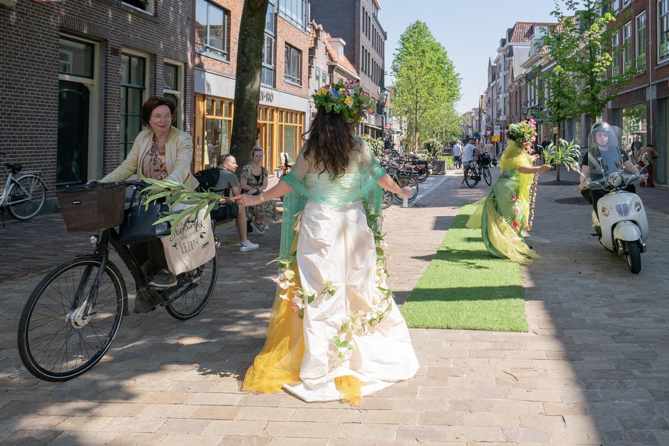 Bosnimfen zingen fietsers toe op de Alkmaarse winkelstraat de Laat in Alkmaar.