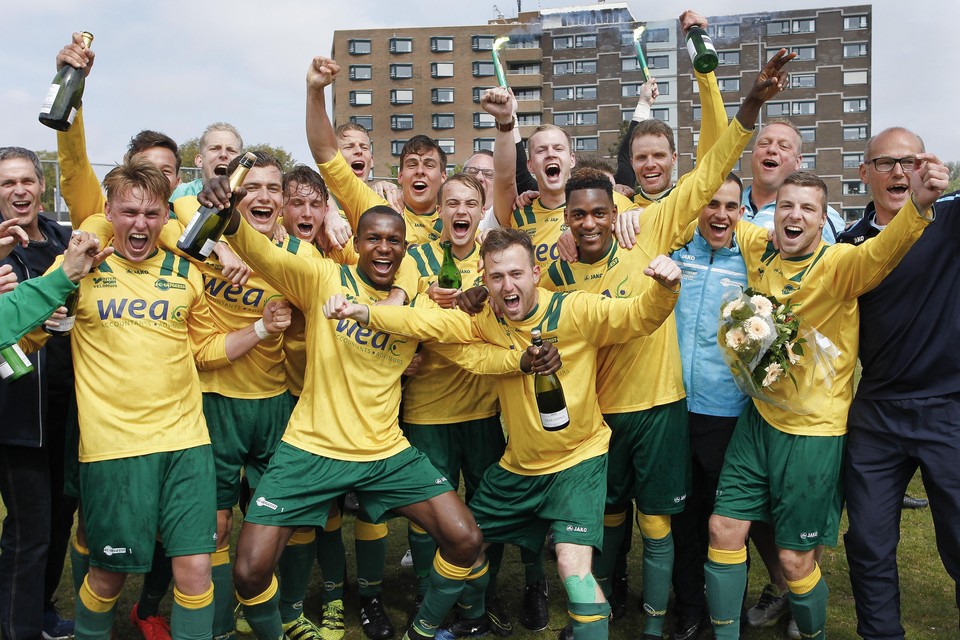 De spelers en staf van FC Uitgeest vieren de titel op het veld van Stormvogels.