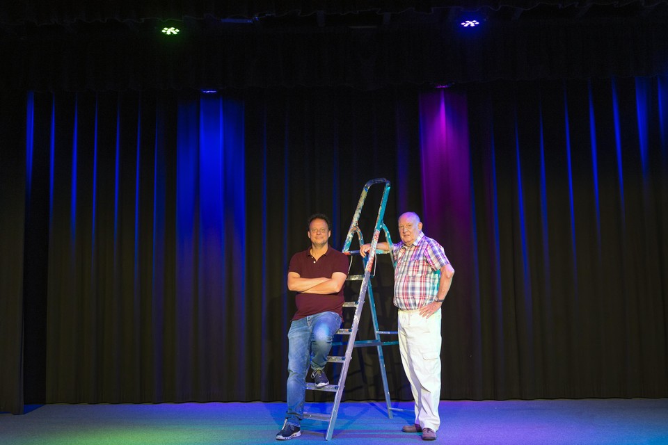 Het brede kleurenpalet van de nieuwe theaterlichtmachine in het Dorpshuis. Op het podium Richard Tang (l.) en Jan Holvast.