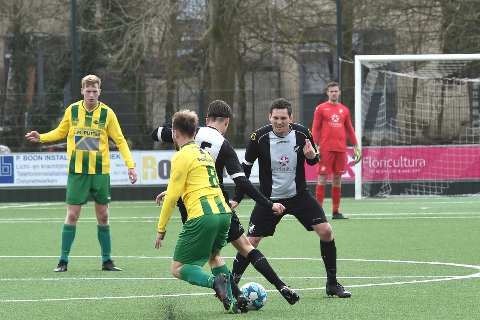 Niels van de Woude (rechts) ziet hoe Kick Smit (8) van FC Uitgeest zit in de rug zit van Bas de Groot.