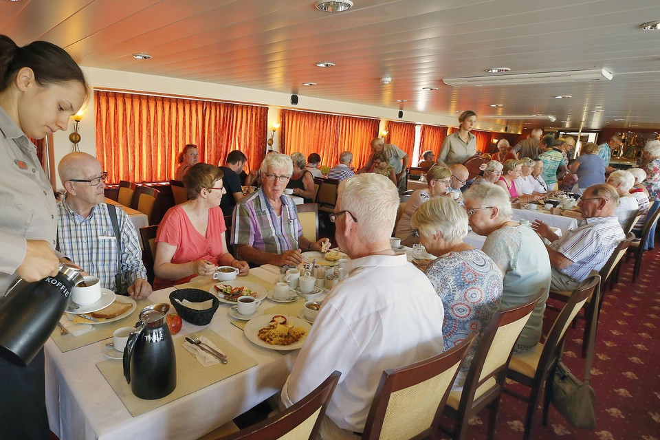 Folklore of niet: met de gordijntjes dicht tegen de warmte beginnen de 85  passagiers van cruiseschip Azolla aan de lunch in de Schager recreatiehaven.