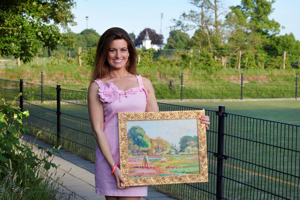 Esther Jansen poseert met het schilderij Bollenveld met villa Castagnola. Het doek is gemaakt waar nu de hockeyvelden zijn.