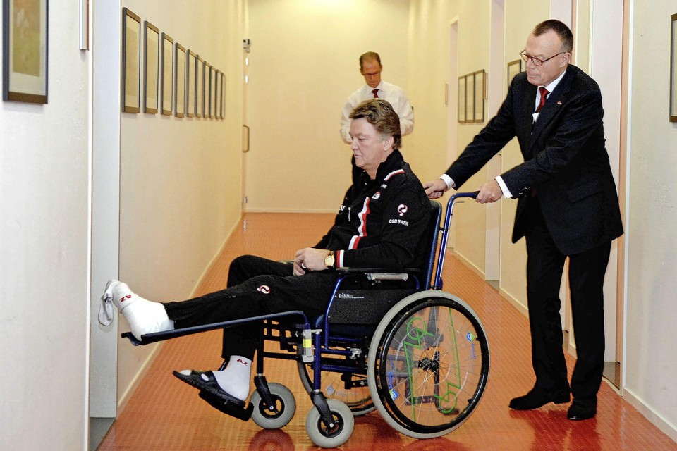 Elftalleider Piet Hartland rijdt Louis van Gaal door de gangen van het AZ-stadion.