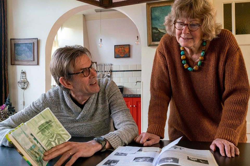 Teun en Annemieke Jansen bekijken het boek ’De Noord-Hollandse familie Van Baar’. Links het fotomapje met 78 foto’s van dorpsgezichten in Warmenhuizen.