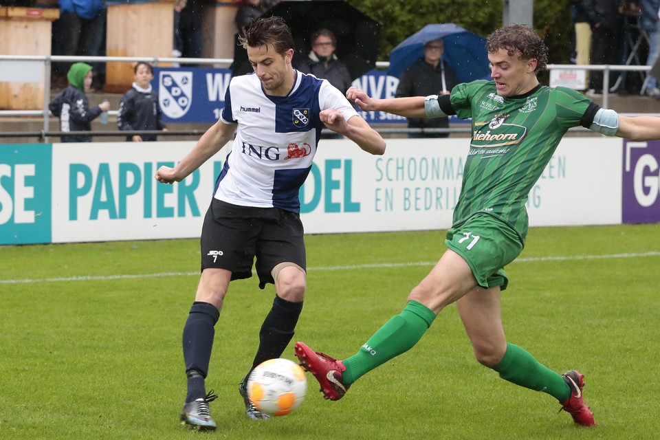Hollandia-speler Nick Kuin (rechts) probeert de bal van Joost Heerschop af te pakken.