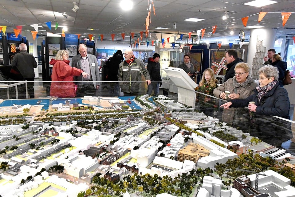 Tijdens een drukbezochte openstelling van Projectwinkel Stadshart buigen bezoekers zich over de maquette van het stadshart.