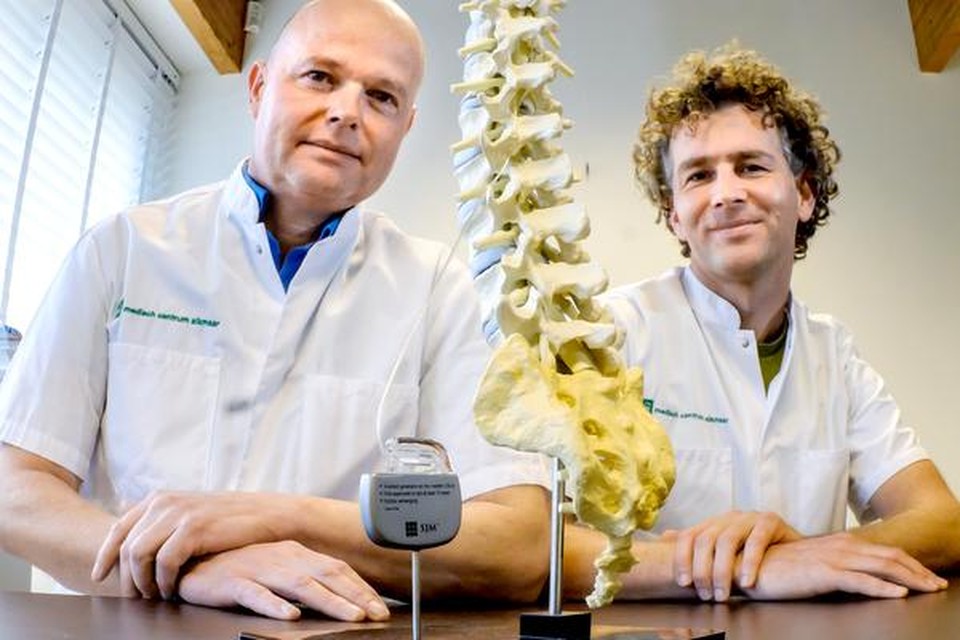 
Cees-Jan Oostwouder (links) en Harmen Pelleboer met een model van een ruggegraat en een neurostimulator. 
