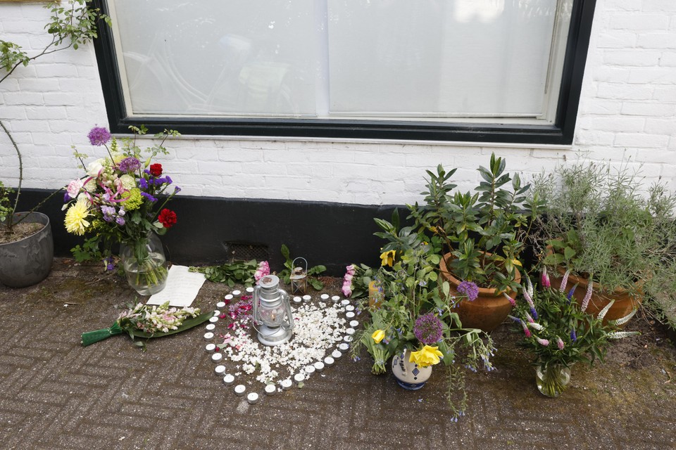 Buurtbewoners hebben bloemen gelegd voor de woning aan de Laanstraat waar zondagavond een vrouw om het leven kwam bij een steekincident.