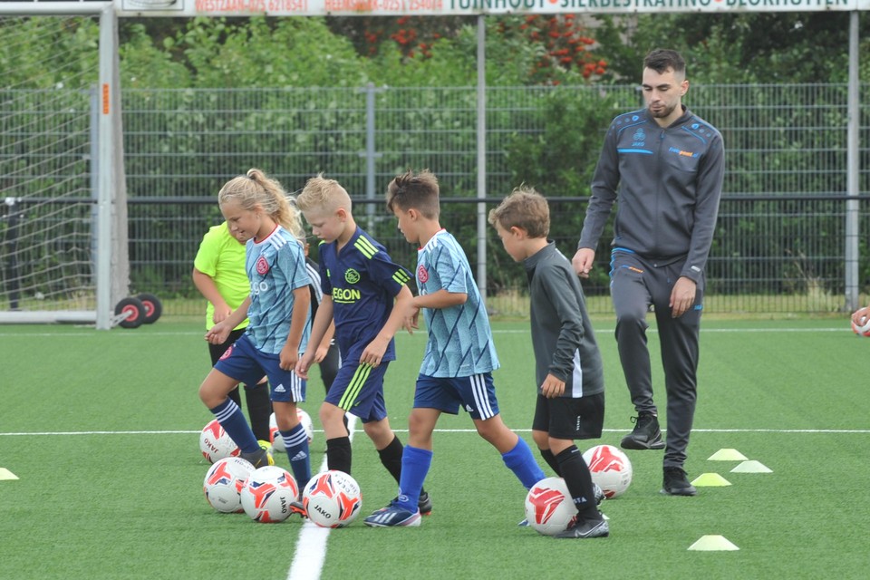 DEM-speler Mehmet Gencer geeft de kids voetballes op de open dag.