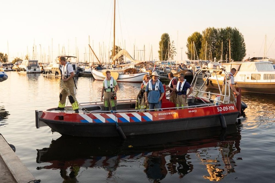 Waterscooterbestuurder Benno Vermeer staat in blauw shirt op de brandweerboot.