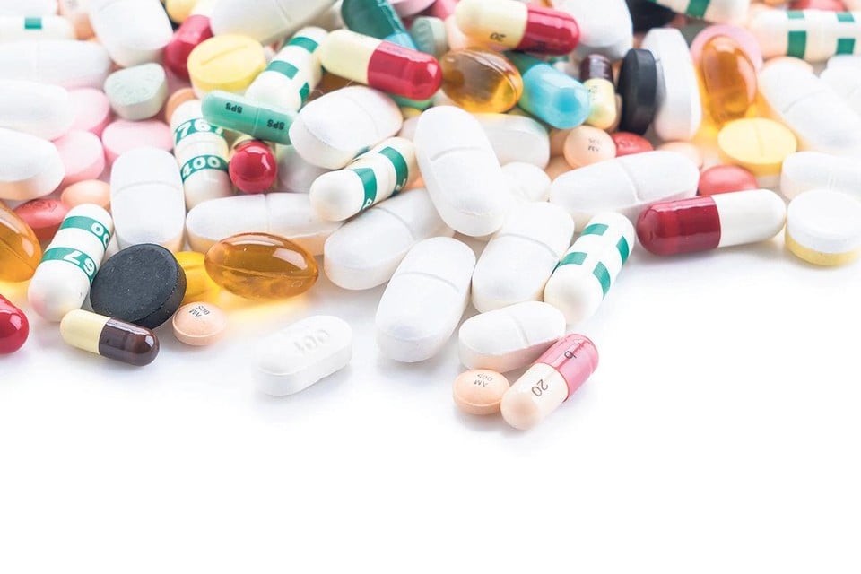 packings of pills and capsules of medicines on white background