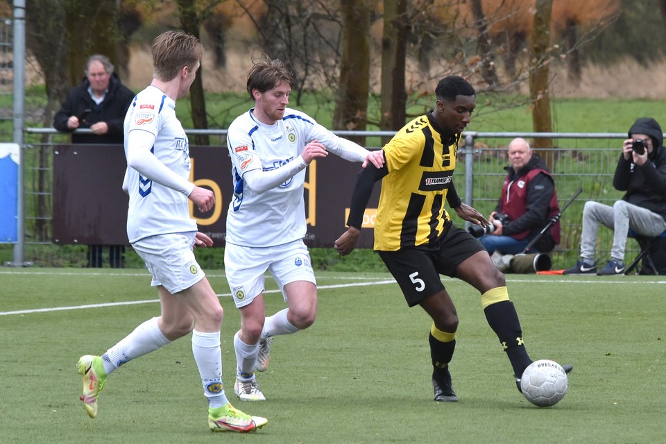 Maxwell Frimpong probeert twee tegenstanders van FC Lisse van de bal te houden.